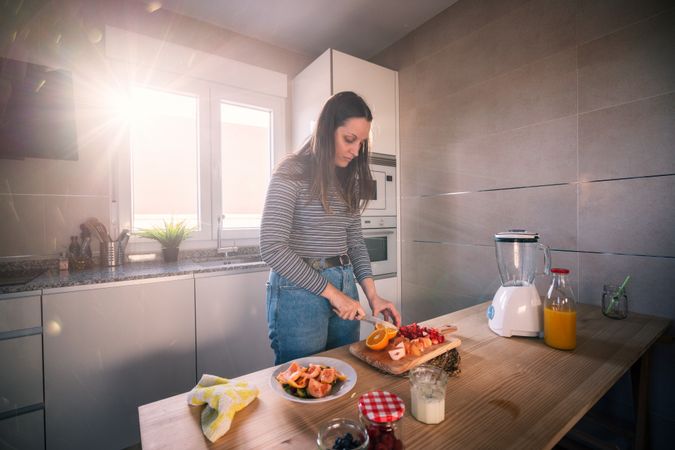 Woman cutting fruits in kitchen