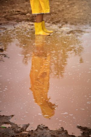 Crop child standing in puddle