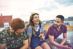 Friends catching up and talking on the rooftop with beer