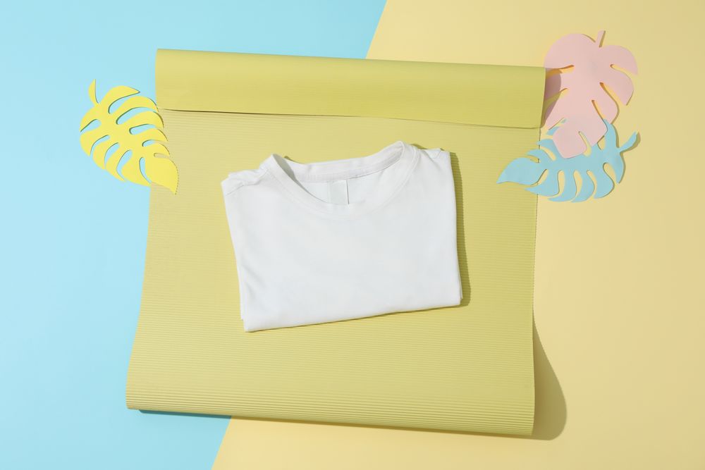 Folded t-shirt on color decorated background, space for text