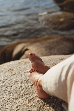 Person relaxing while sitting on stone