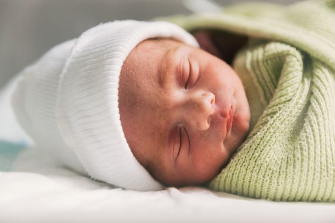 Newborn baby sleeping in crib. Babyhood concept.