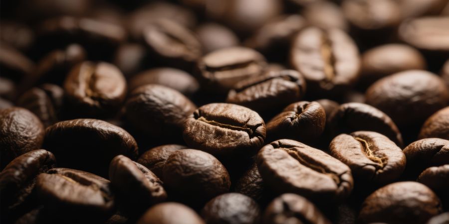 Full frame macro shot of dark roasted brown coffee beans filling the entire image