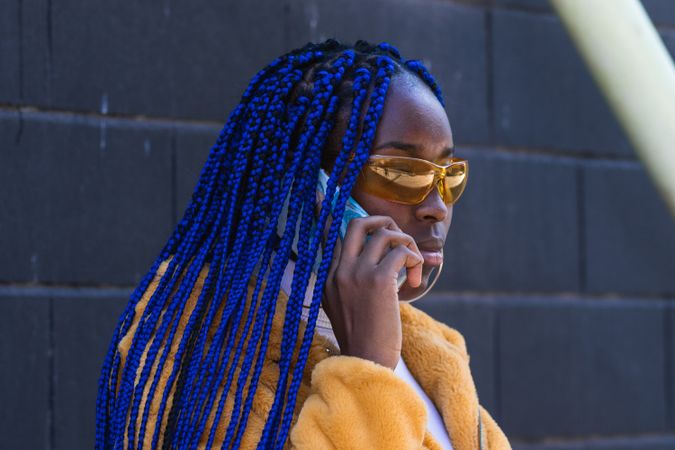 woman in trendy outfit speaking on cellphone in city