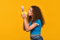 Girl playfully kissing piggy bank, symbolizing love for saving