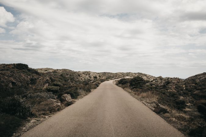 Cloudy sky over hill with road