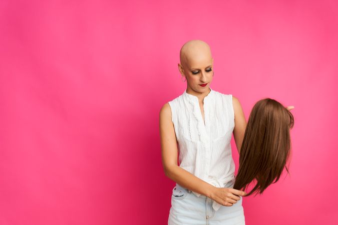 portrait of a woman suffering from breast cancer preparing the wig to cover her head without hair