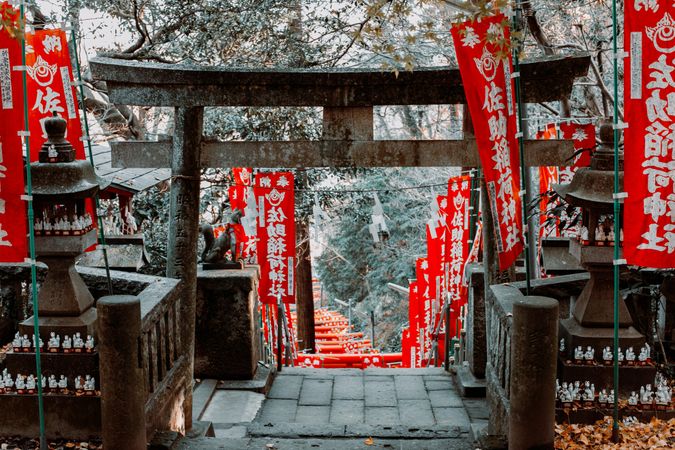 Wooden Torii gate surrounded with red flags in Japan