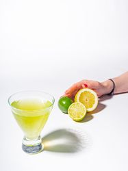 Cocktail glass with lemon juice and sliced citrus