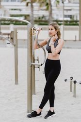 Sportswoman resting after workout in a sandy beach