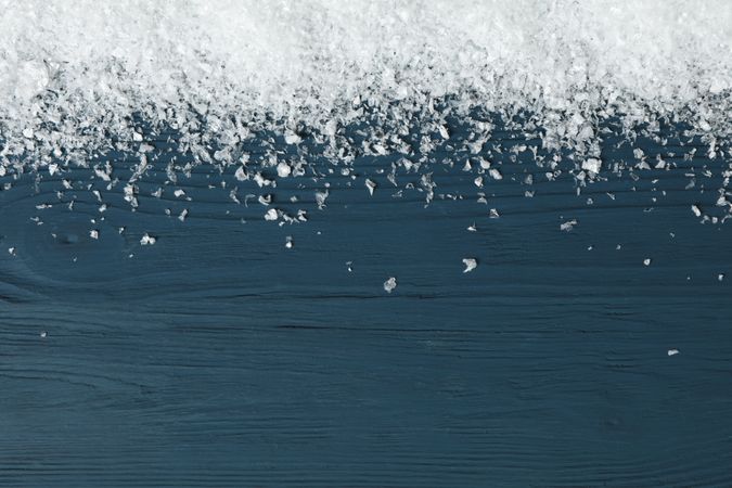 Snow on wooden background, space for text