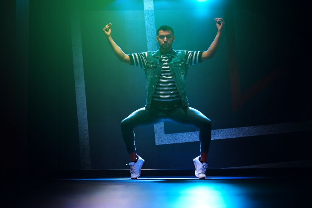 bearded man dancing in spotlight