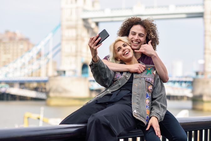 Girlfriend and boyfriend taking selfie in front of famous British bridge