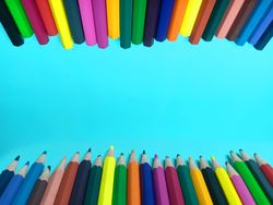 color pencils on a light blue background provide space for writing or words
