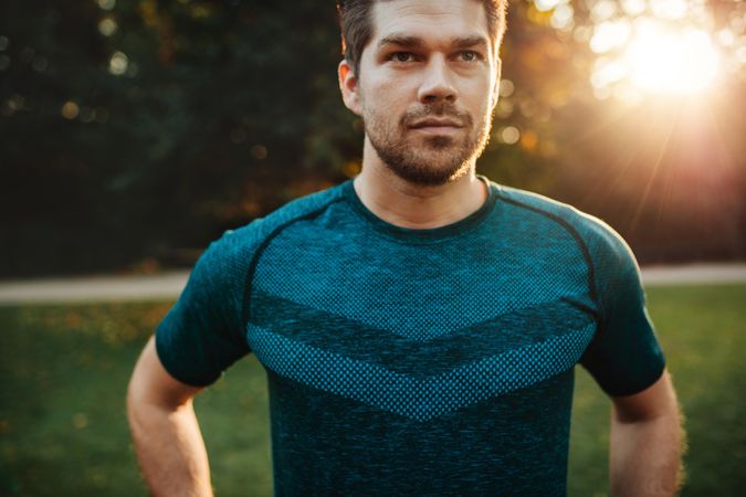 Close up portrait of fit young man in sportswear standing outdoors