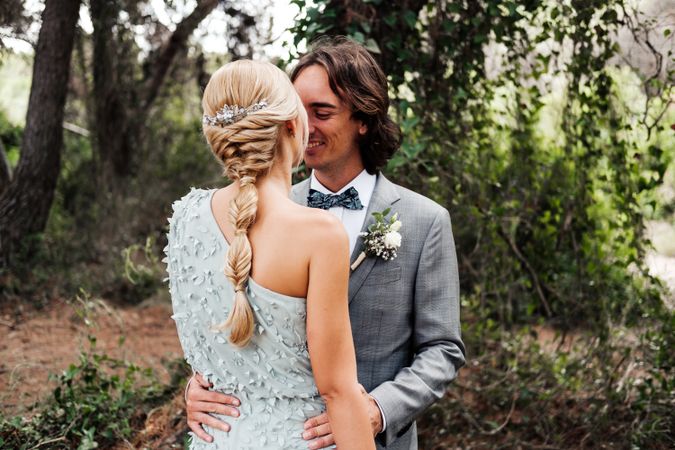 Happy married couple in wedding clothing at forest
