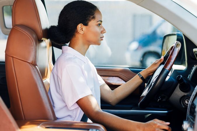 Confident young woman driving car