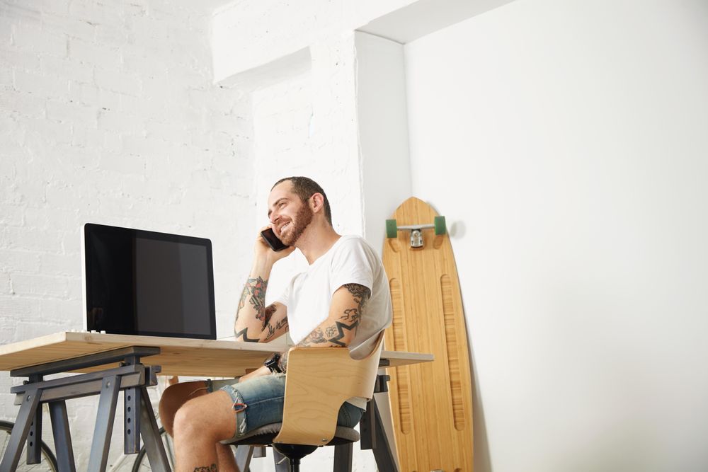 Man talking on phone in modern bright home office