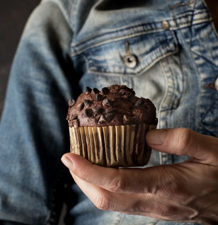 Crop woman with chocolate banana muffin