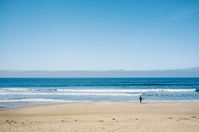 Sportsman running on beach near sea