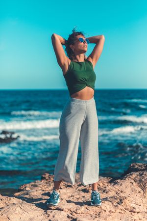 Stylish woman standing near sea