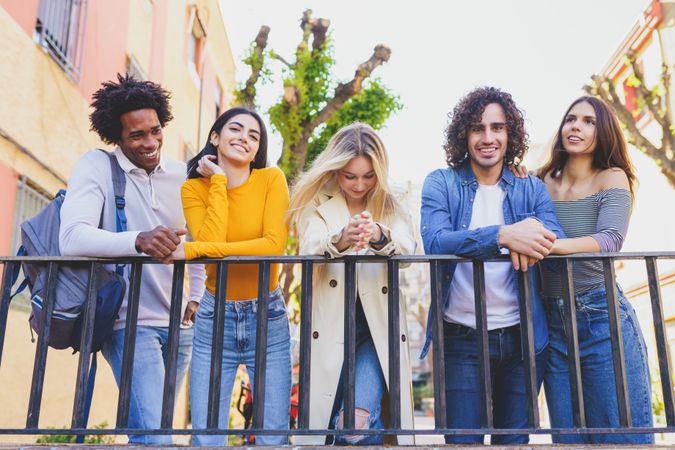 Male and female friends smiling with each other outside