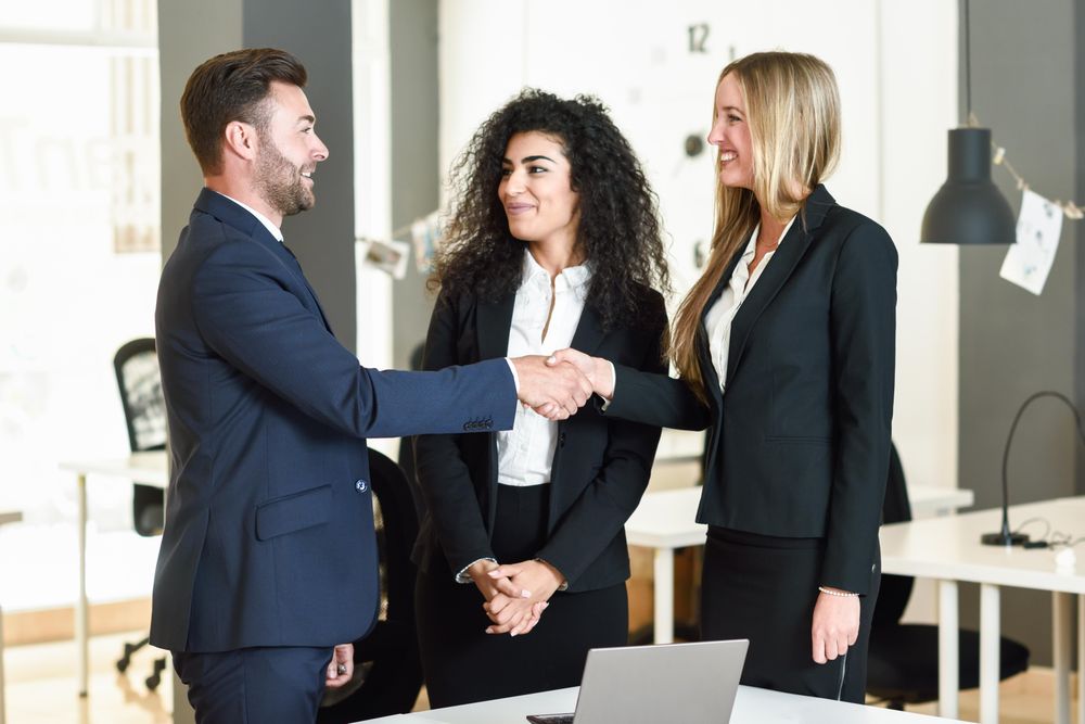 Colleagues shaking hands after a successful meeting in office