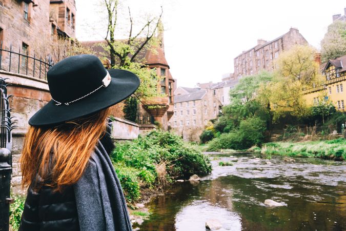Woman contemplating city aged stone buildings