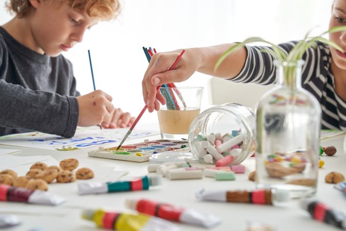 Children painting with paints at table