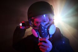 Boy in respirator with walkie talkie in dark studio