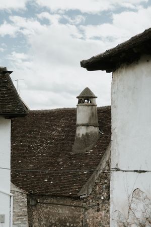 Tower near brick building and cloudy sky