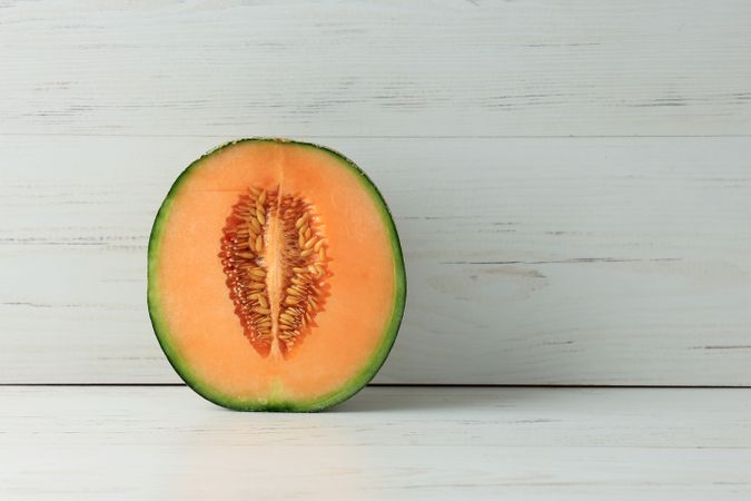 Melon Cantaloupe, Halved and Standing on Wooden Background
