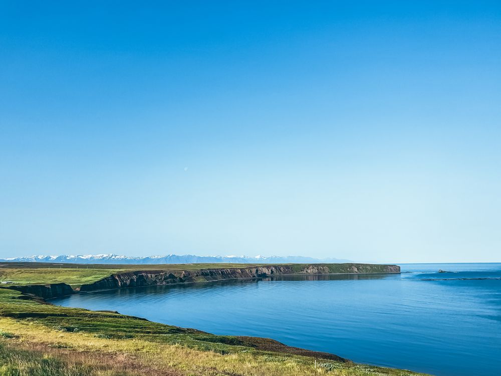 Green grass field over seashore in Iceland