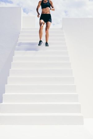 Cropped shot of athletic woman running down stairs