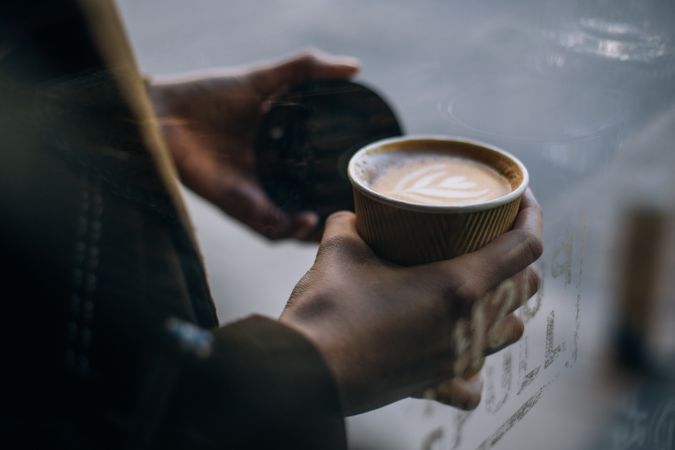 Woman with to go cappuccino and lid