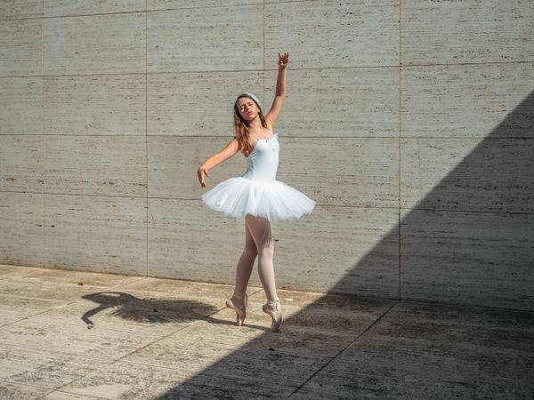 Ballerina doing ballet posing in classroom