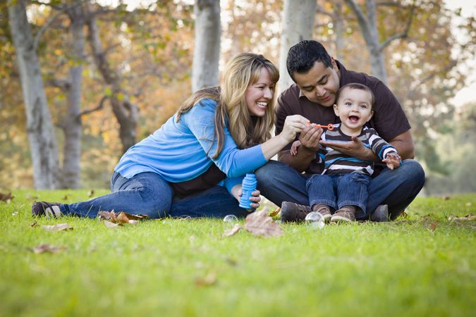 Happy Family Playing with Bubbles In The Park