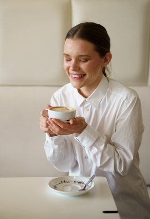 Businesswoman enjoying morning coffee alone in a chic cafeteria
