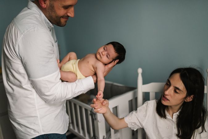 Parents holding baby in room