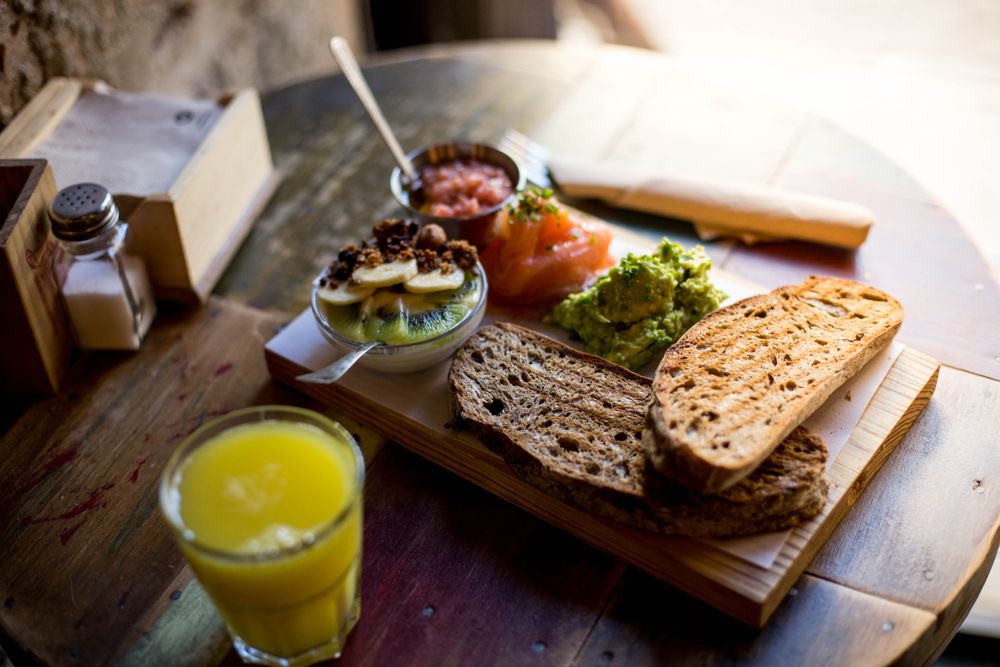 Crunchy toast with avocado spread, tomato, fresh salmon and philadelphia cheese