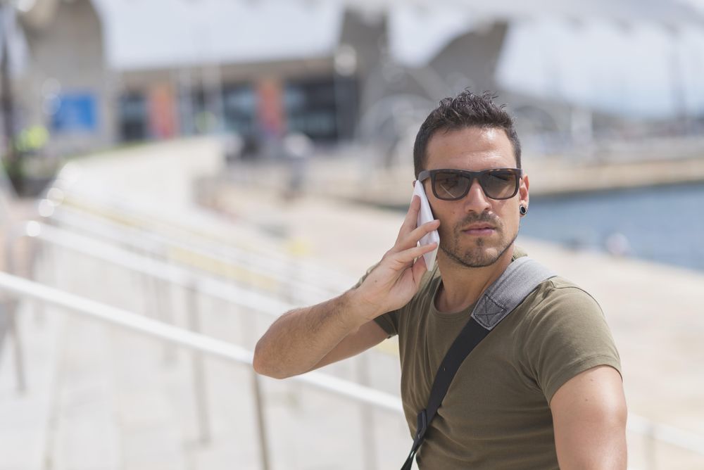Male looking around while talking on cellphone