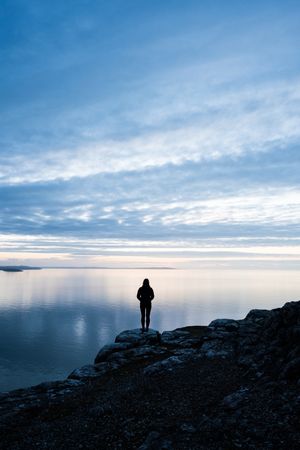 anonymous woman on rocky coastline