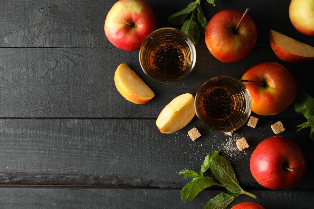 Composition with cider, sugar and apples on wooden background