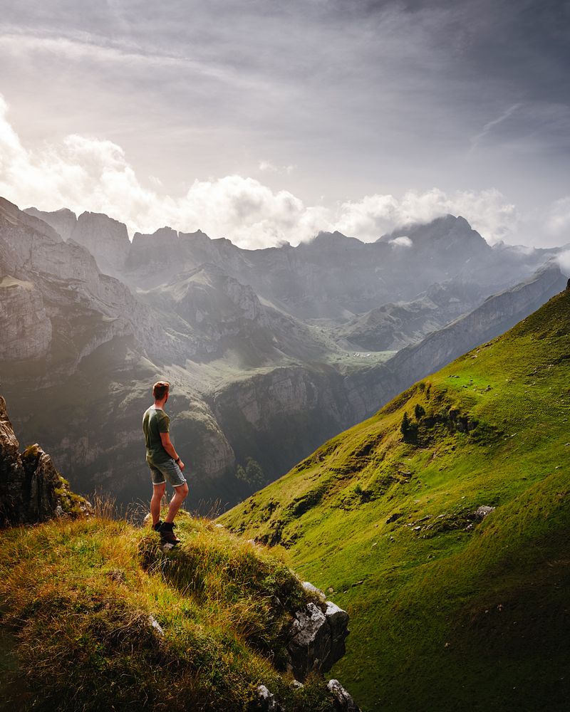 Man standing on rock looking at the mountains