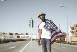 Happy black man with flying American flag