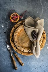 Top view of rustic Christmas table setting with decorative dried orange slices and pine cones