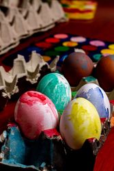Set of painted Easter eggs in container on table