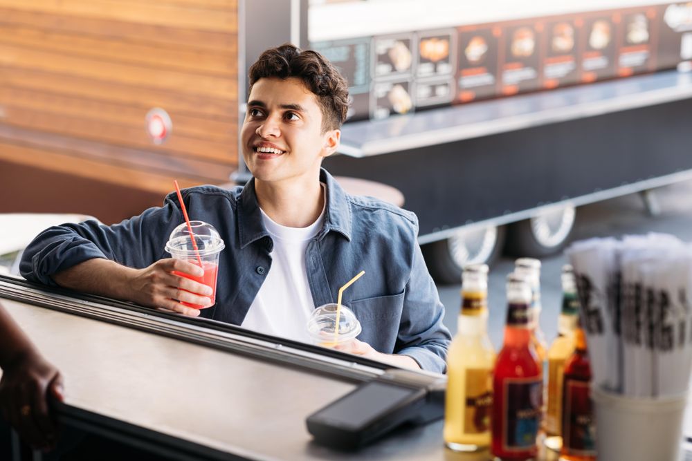 Male customer of food truck picking up two fresh juices