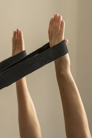 Close up of a woman's hands holding a yoga strap for an assisted stretching exercise.