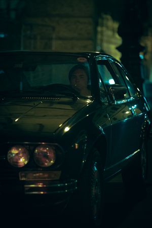 Young man driving an old car at night